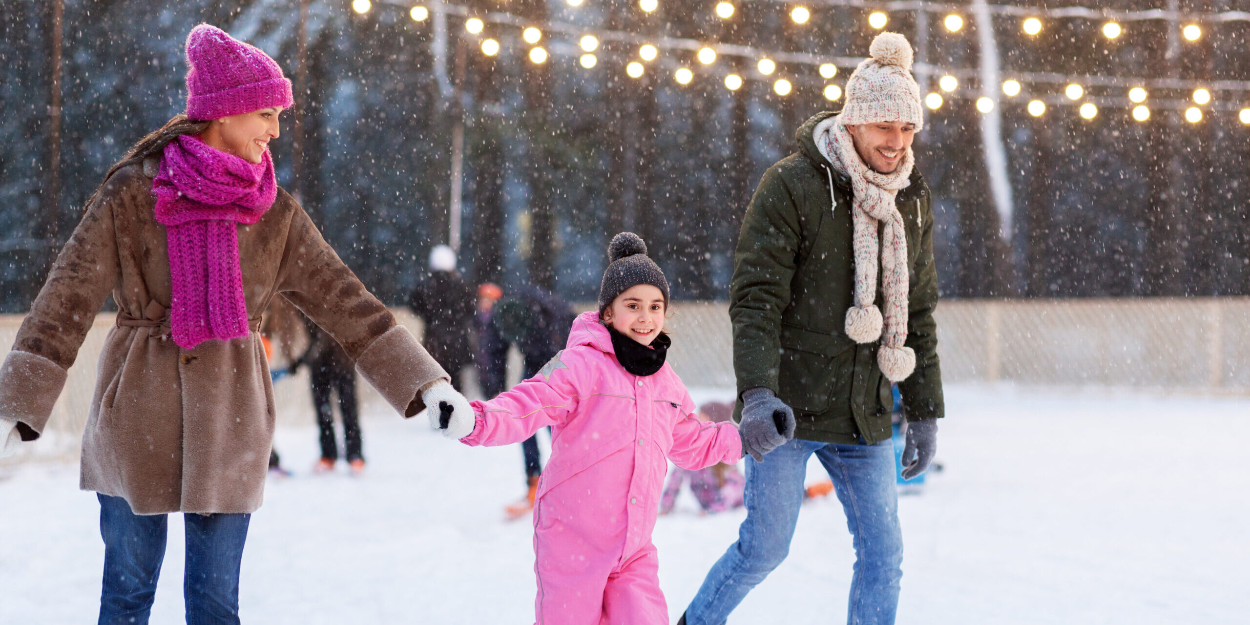 happy family at outdoor skating rink in winter christmas