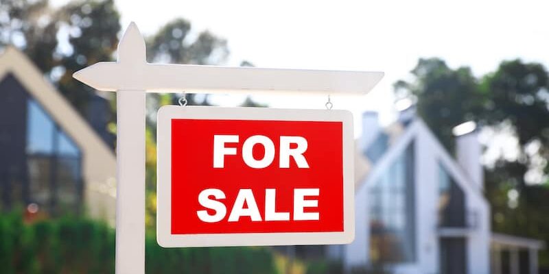 Red real estate sign near house outdoors on sunny day Preparing Your Home For Sale